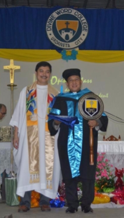 Fr. Edwin Fernadez, SVD and Fr. Roberto J. Ibay, SVD, holding the DWCU Mace and flag